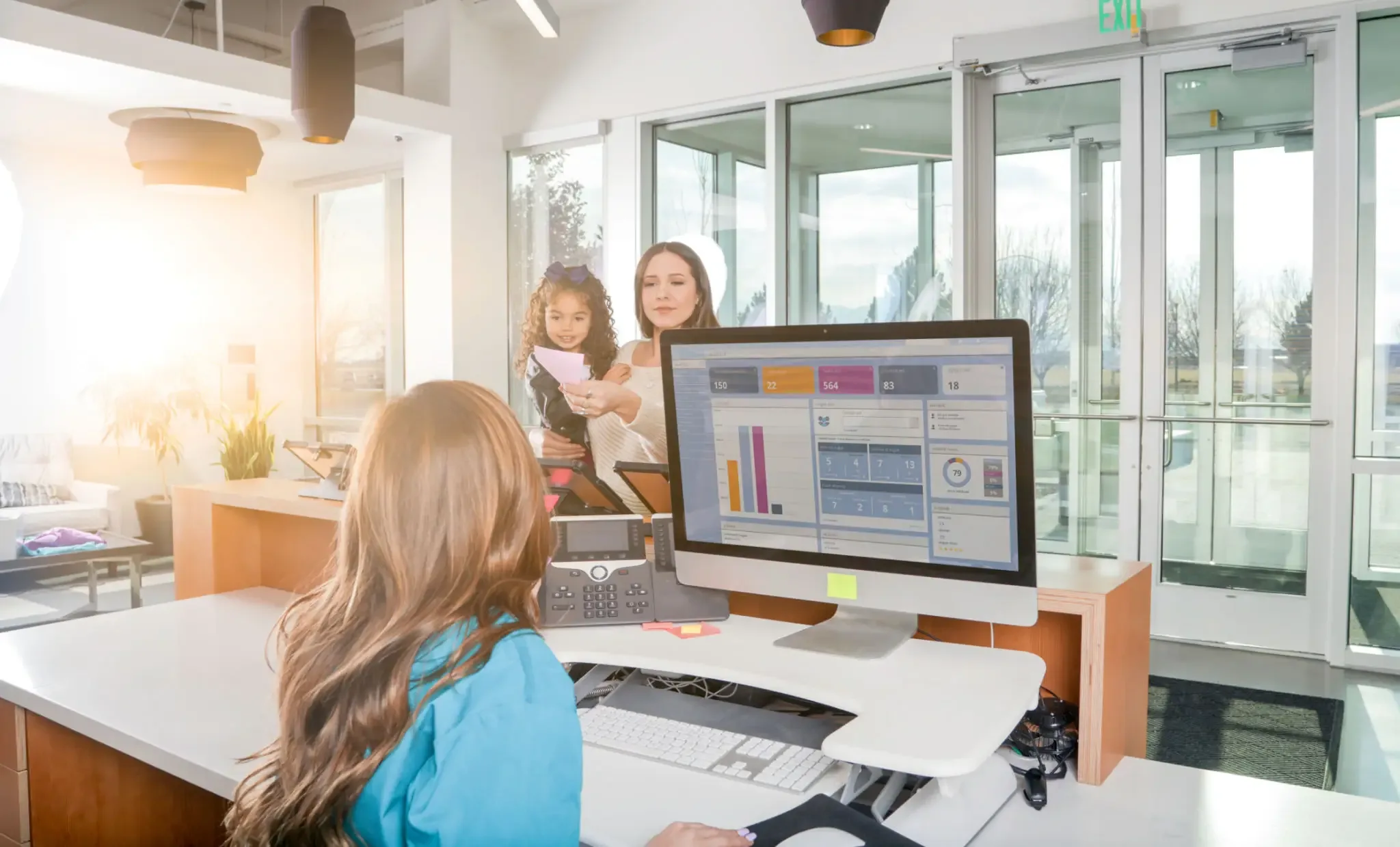 A receptionist checking in a family at the front desk